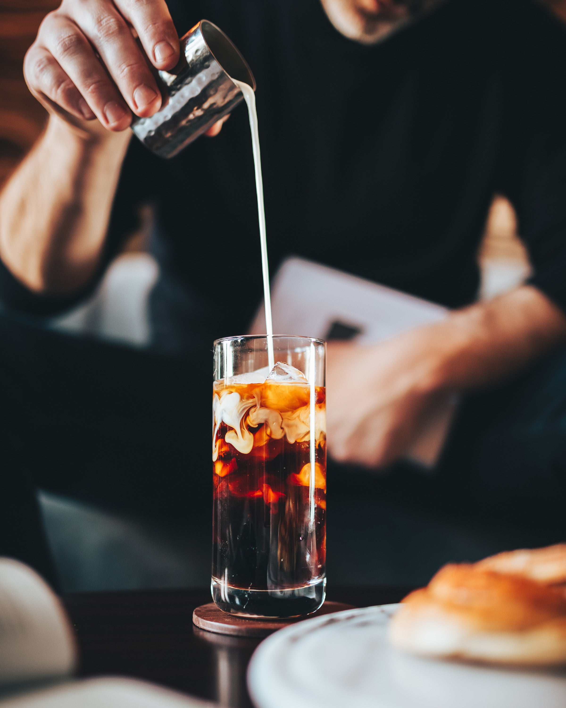 Afficionado Coffee Roasters Magical Cold Brew, pouring milk into glass of coffee
